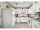 Bright kitchen with gray wood floors, white cabinets, granite counters, and stainless appliances at 546 Paden Dr, Lawrenceville, GA 30044