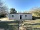 Tan single-story house with black door, two windows, and small yard at 1876 Flat Shoals Se Rd, Atlanta, GA 30316