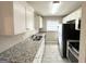 Clean kitchen with white cabinets, granite countertops and stainless steel appliances at 2729 Pinella Sw Dr, Atlanta, GA 30331