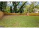 Expansive backyard with lush green grass, mature trees, and a wooden fence, perfect for outdoor activities at 1302 Ladd St, Atlanta, GA 30310