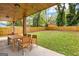 Outdoor patio area with a wooden table and chairs overlooking a lush green yard and wooded fence at 1302 Ladd St, Atlanta, GA 30310