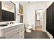 Modern bathroom with white vanity, sleek fixtures, and stylish tile flooring, with a view to the walk-in closet at 1302 Ladd St, Atlanta, GA 30310