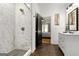 Well-lit bathroom featuring a shower with marble tiling, black door, and a view into the bedroom at 1302 Ladd St, Atlanta, GA 30310