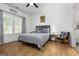 Neutral bedroom with wood-look floors features bright windows, modern gray furniture and a ceiling fan at 1302 Ladd St, Atlanta, GA 30310