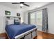Bedroom featuring wood-look floors, a ceiling fan, windows with decorative curtains and a modern bed at 1302 Ladd St, Atlanta, GA 30310