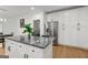Bright kitchen showcases granite counters, stainless steel appliances, white cabinets and an island with bar stool seating at 1302 Ladd St, Atlanta, GA 30310