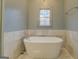 Bathroom with free-standing tub and marble tile at 960 Todd Dr, Covington, GA 30014