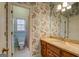 Bathroom with wood vanity, patterned wallpaper, and a toilet at 960 Todd Dr, Covington, GA 30014