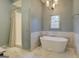 Spa-like bathroom with soaking tub and marble tile at 960 Todd Dr, Covington, GA 30014