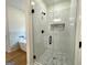 Modern bathroom featuring a glass-enclosed shower with mosaic tile and a soaking tub at 4619 Parkwood Rd, Social Circle, GA 30025