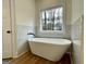 Elegant bathroom with a freestanding tub, marble accents, and a large window at 4619 Parkwood Rd, Social Circle, GA 30025