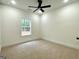 Bright bedroom with neutral carpet, a window with tree view, and white trim at 4619 Parkwood Rd, Social Circle, GA 30025