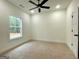 Bright bedroom with a ceiling fan, large window offering natural light and neutral carpet flooring at 4619 Parkwood Rd, Social Circle, GA 30025
