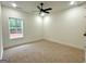 Well-lit bedroom featuring neutral carpet, a window view, and a modern ceiling fan at 4619 Parkwood Rd, Social Circle, GA 30025