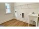 Functional laundry room with ample lighting, a utility sink, shelving, and wood-style laminate floors at 4619 Parkwood Rd, Social Circle, GA 30025