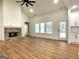 Bright living room with a cozy brick fireplace, large windows, and access to the kitchen at 4619 Parkwood Rd, Social Circle, GA 30025