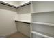 Neat walk-in closet featuring white shelving and black hanging rods for organized storage at 4619 Parkwood Rd, Social Circle, GA 30025