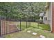Fenced backyard with lush green grass, mature trees, and landscaping at 230 Hedgewick Way, Tyrone, GA 30290