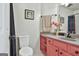 Bright bathroom features pink vanity with granite countertop, toilet and black framed art at 230 Hedgewick Way, Tyrone, GA 30290