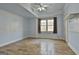 Clean bedroom featuring hardwood floors, light blue walls, and a window at 230 Hedgewick Way, Tyrone, GA 30290