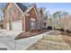 Elegant brick home showcasing a two-car garage and a charming walkway lined with landscape lighting at 230 Hedgewick Way, Tyrone, GA 30290