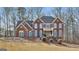 Stately brick home with striking blue shutters and a welcoming front porch, set on a manicured lawn at 230 Hedgewick Way, Tyrone, GA 30290