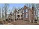 View of the beautiful two-story red brick home featuring blue shutters and manicured front yard at 230 Hedgewick Way, Tyrone, GA 30290