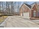 Three-car garage with a large concrete parking pad at 230 Hedgewick Way, Tyrone, GA 30290