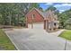 Side view of the home featuring a three-car garage and extra-long driveway at 230 Hedgewick Way, Tyrone, GA 30290
