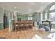 Open-concept kitchen featuring custom green cabinetry, stainless steel appliances, and a dining area with ample seating at 230 Hedgewick Way, Tyrone, GA 30290