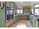 Gourmet kitchen featuring custom green cabinetry, stainless steel appliances and hardwood flooring at 230 Hedgewick Way, Tyrone, GA 30290