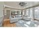 Bright living room featuring large windows, a ceiling fan and an open view of the kitchen at 230 Hedgewick Way, Tyrone, GA 30290