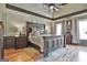 A large main bedroom features an oversized bed, a tray ceiling, and two windows for natural light at 230 Hedgewick Way, Tyrone, GA 30290
