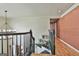 A staircase with dark wood railings adorned with green plants, bathed in natural light at 230 Hedgewick Way, Tyrone, GA 30290