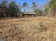 Small house on a lot with cleared land and trees at 8025 Creekwood Dr, Fairburn, GA 30213