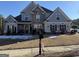 Two-story house with gray siding, stone accents, and a landscaped lawn at 100 Harmony Ct, Dallas, GA 30157