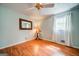 Bright bedroom with wood floors, a window with curtains, and a side table with a lamp at 3170 Ebenezer Rd, Marietta, GA 30066