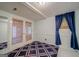 Bonus room with large blue and white rug, walk out doors and blue curtains at 3170 Ebenezer Rd, Marietta, GA 30066