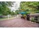 Spacious wooden deck with outdoor seating, grill, and an umbrella, perfect for entertaining guests at 3170 Ebenezer Rd, Marietta, GA 30066