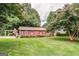 Brick home featuring a lush lawn, manicured shrubs, and a charming pergola at 3170 Ebenezer Rd, Marietta, GA 30066