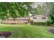 Charming brick home with a lush green lawn, manicured hedges, and large trees at 3170 Ebenezer Rd, Marietta, GA 30066