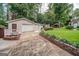 Garage with a large driveway, brick-lined flower beds, and well-maintained landscaping at 3170 Ebenezer Rd, Marietta, GA 30066