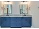 Double vanity bathroom with blue cabinets, granite countertops, and large mirrors at 65 Oakhurst Trl, Sharpsburg, GA 30277