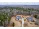 Expansive aerial view of a traditional two-story brick home with a large yard, wooded area, and long driveway at 25 Abelia Dr, Covington, GA 30014
