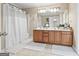 Bathroom featuring double sink vanity, ceramic tile floor and shower with white curtain at 25 Abelia Dr, Covington, GA 30014