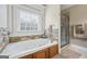 Bathroom with stone tile, a separate shower, and a soaking tub at 25 Abelia Dr, Covington, GA 30014