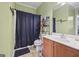 Bathroom with a cherry wood vanity and a shower with a black curtain at 25 Abelia Dr, Covington, GA 30014