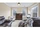A bedroom featuring two windows, a dresser and a leather chair at 25 Abelia Dr, Covington, GA 30014