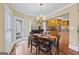 Dining area with view into kitchen featuring a chandelier and wood floors at 25 Abelia Dr, Covington, GA 30014