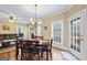 Eat-in dining area with traditional chandelier, wood floors, and large windows at 25 Abelia Dr, Covington, GA 30014